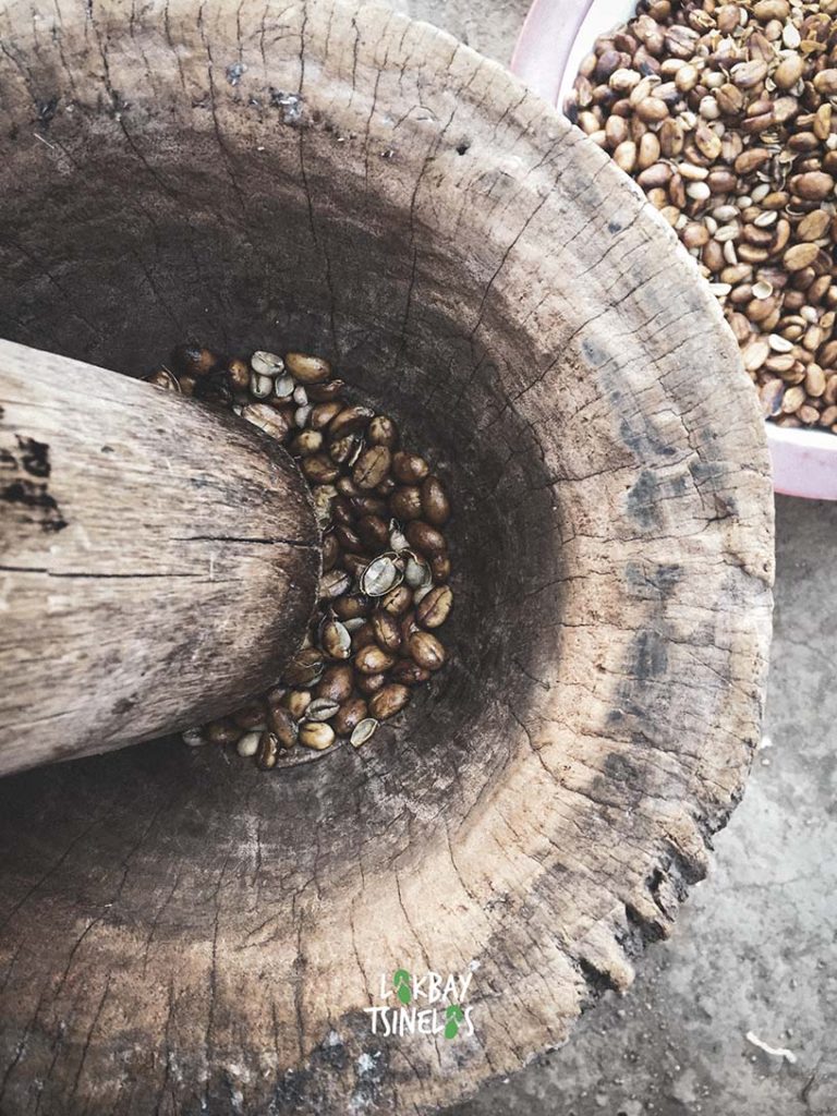 dried coffee beans in the wooden pounder